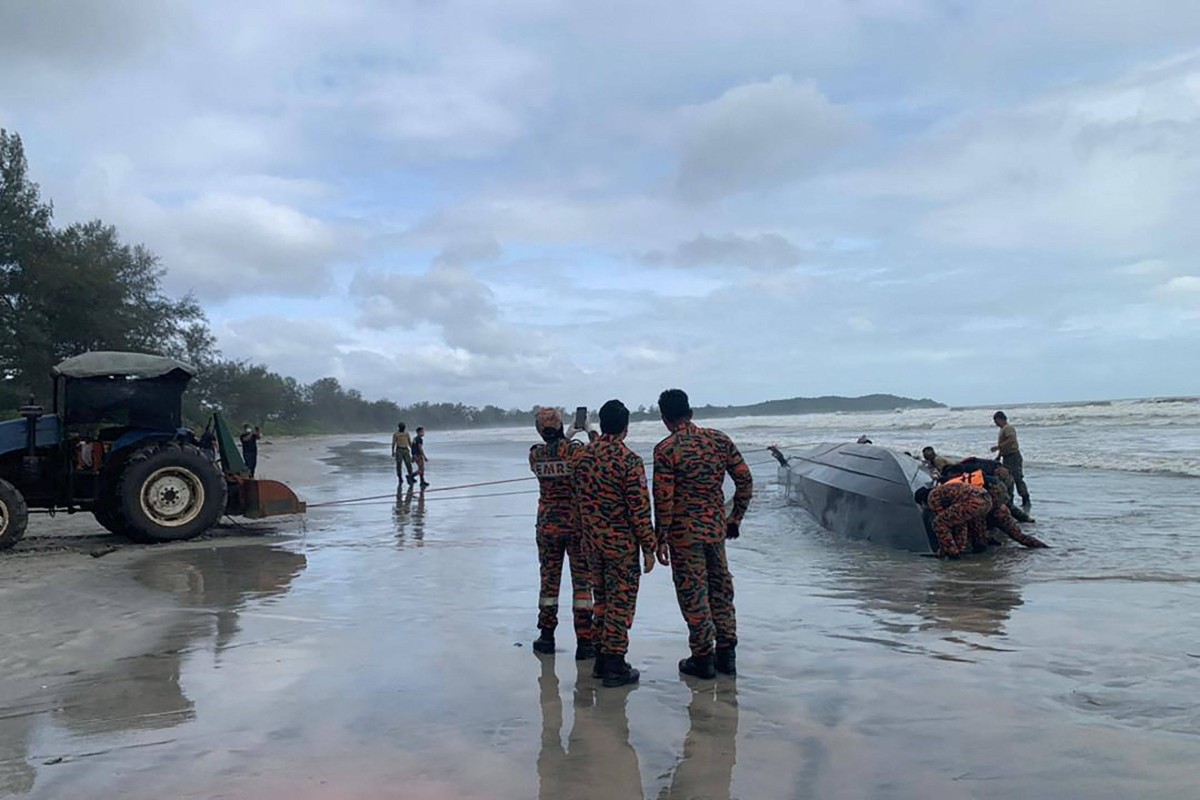 Rescuers bring the vessel onto shore after it capsized near Tanjung Balau off the coast of Johor. Photo: Malaysian Armed Forces/AFP
