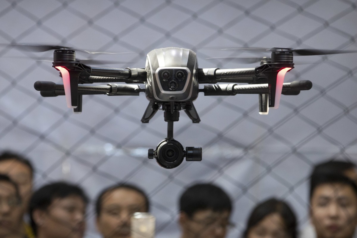 Visitors watch as a drone made by PowerVision hovers during a demonstration at the World Robot Conference in Beijing, Thursday, Aug. 24, 2017. The annual conference is a showcase of China&#39;s burgeoning robot industry ranging from companion robots to those deployed on manufacturing assembly line and entertainment. (AP Photo/Mark Schiefelbein)