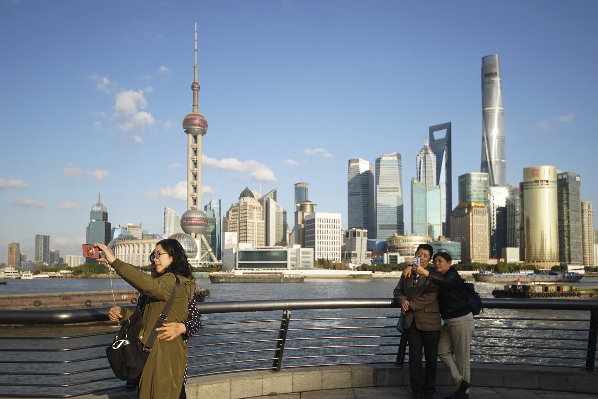People take selfies with the Pudong skyline as they stand on the Bund in Shanghai, China. Kerry Properties has acquired four plots in the city. Photo: AP