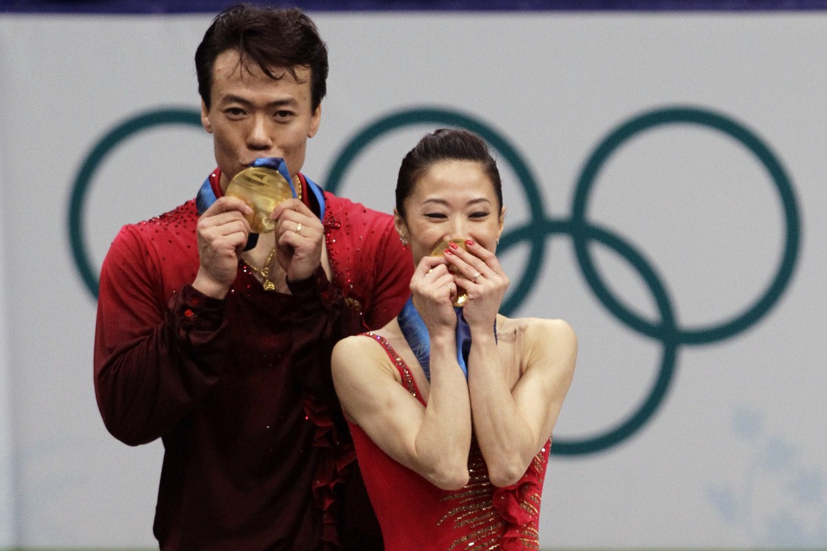 China’s figure skating pioneers Shen Xue and Zhao Hongbo kiss their medals after winning gold at the 2010 Vancouver Winter Olympics. Photo: AP