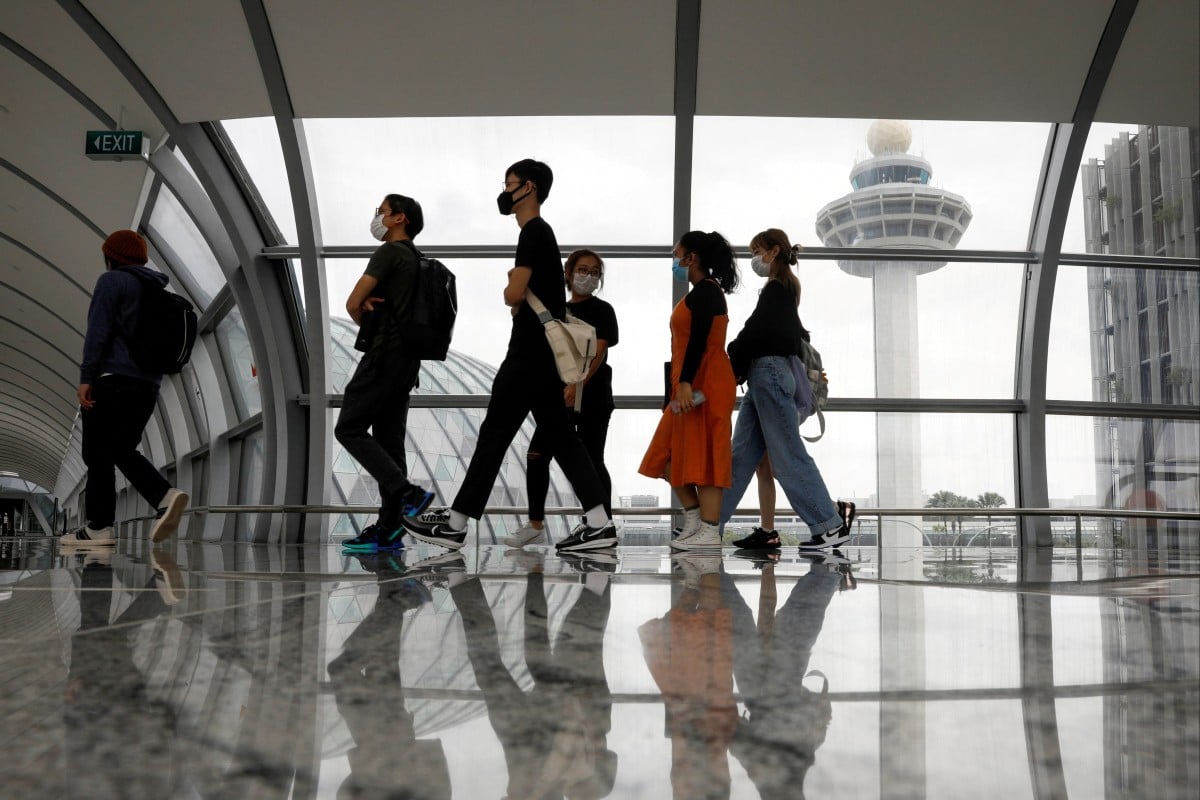 People pass the control tower of Singapore’s Changi Airport. Photo: Reuters