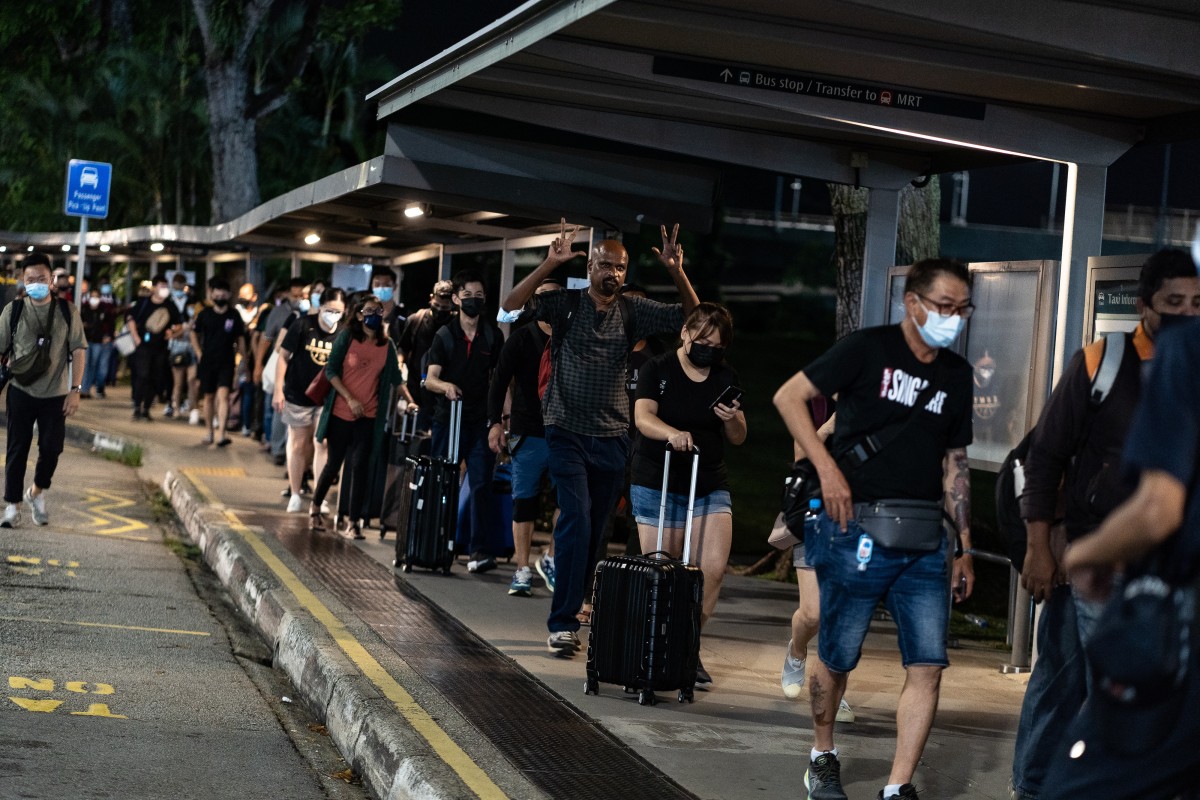 Hundreds of people queue up at the Woodlands Checkpoint to cross the Singapore-Malaysia border at the stroke of midnight for the first time in two years on March 31, 2022. Photo: Anadolu Agency via Getty Images