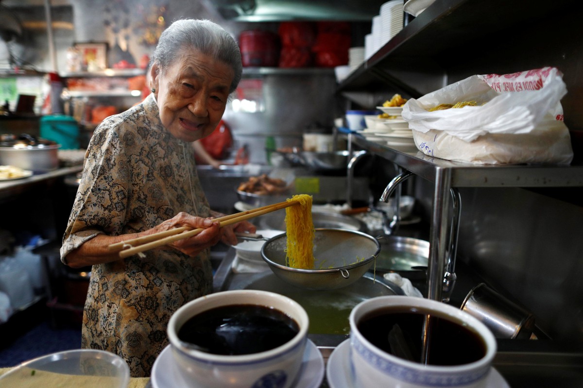 A hawker prepares noodles at her shop in Singapore. Photo: Reuters