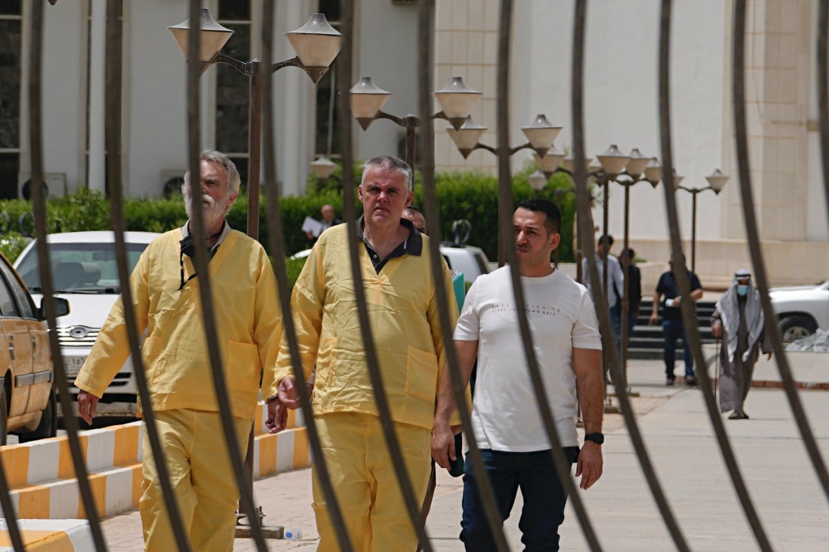 Briton Jim Fitton, left, and German Volker Waldmann, centre, outside a courtroom in Baghdad, Iraq on May 15. The men are accused of smuggling ancient relics out of Iraq. Photo: AP 