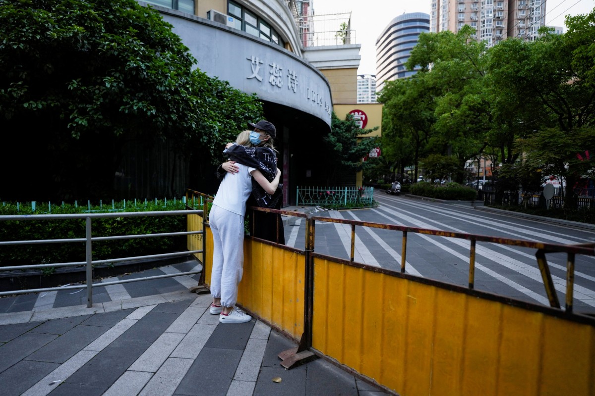 Two women hug at a closed street during lockdown, amid the coronavirus disease (COVID-19) pandemic, in Shanghai on May 16, 2022. Photo: Reuters