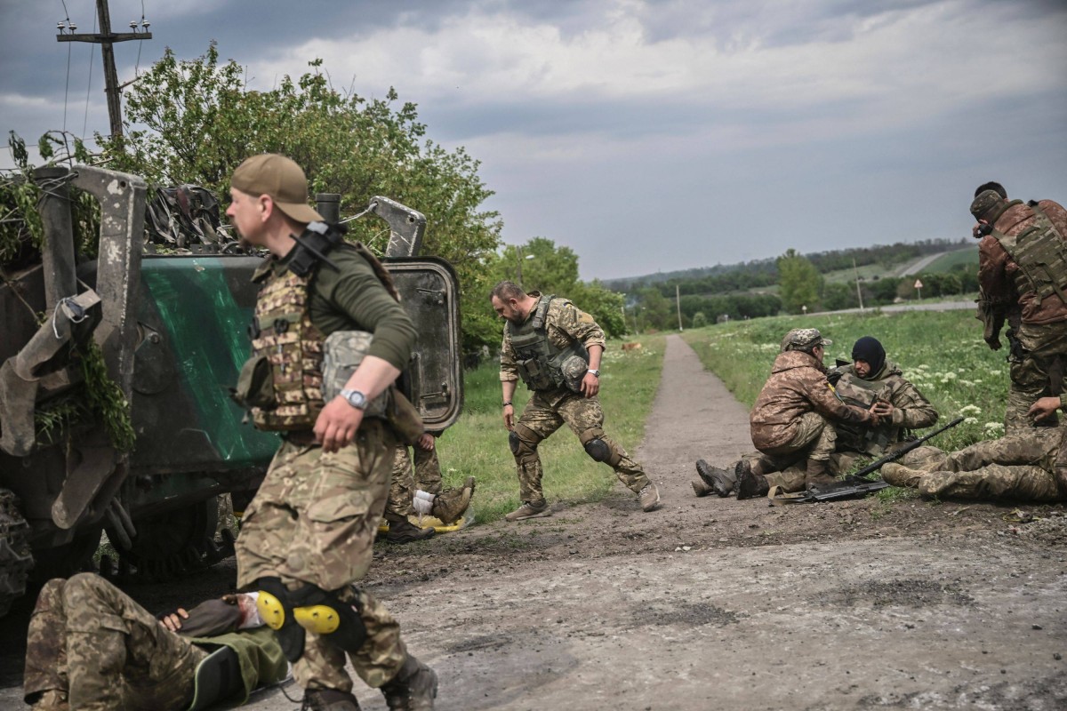 Ukrainian servicemen assist their comrades not far from the frontline in the eastern Ukrainian region of Donbas. Photo: AFP