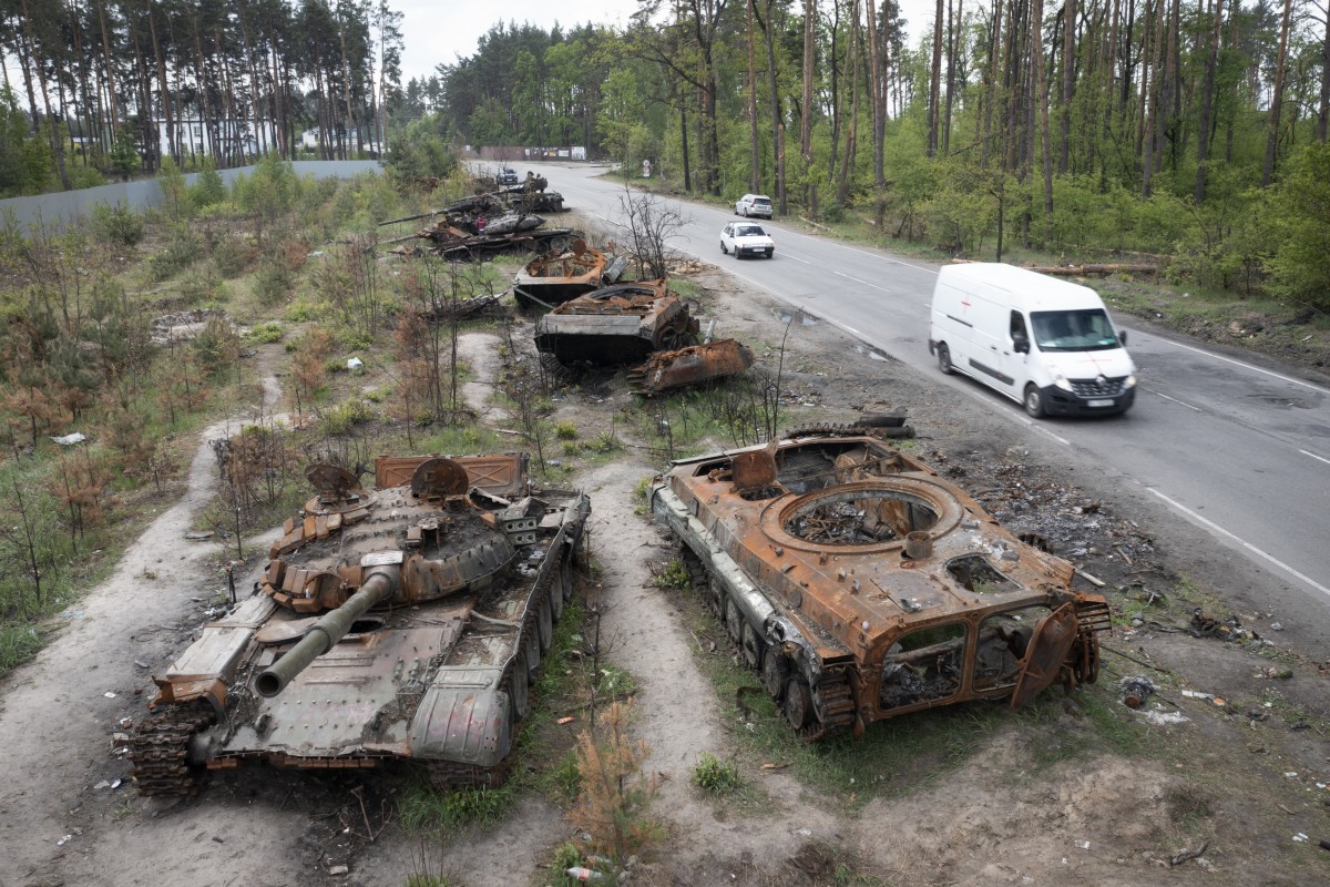 Cars pass by destroyed Russian tanks in the village of Dmytrivka, close to Kyiv, Ukraine on Monday. Photo: APy