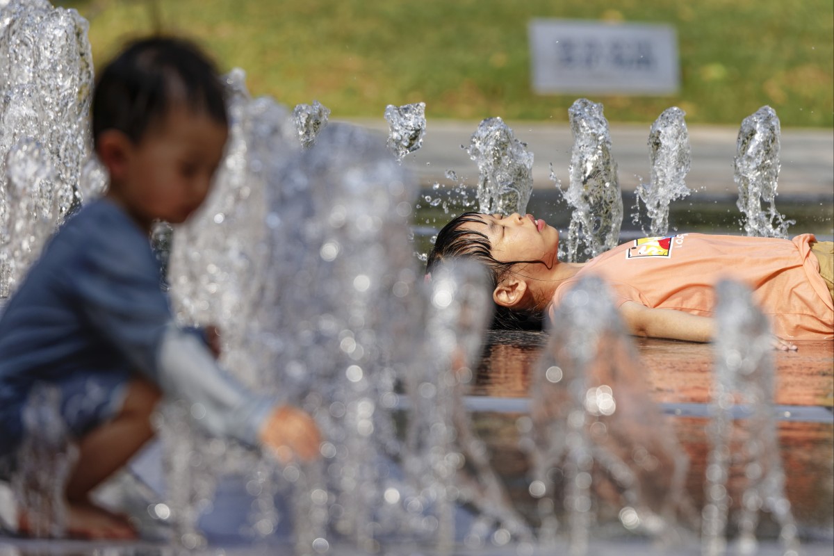 Children in Shanghai try to beat the heat by playing in a fountain. Photo: EPA-EFE