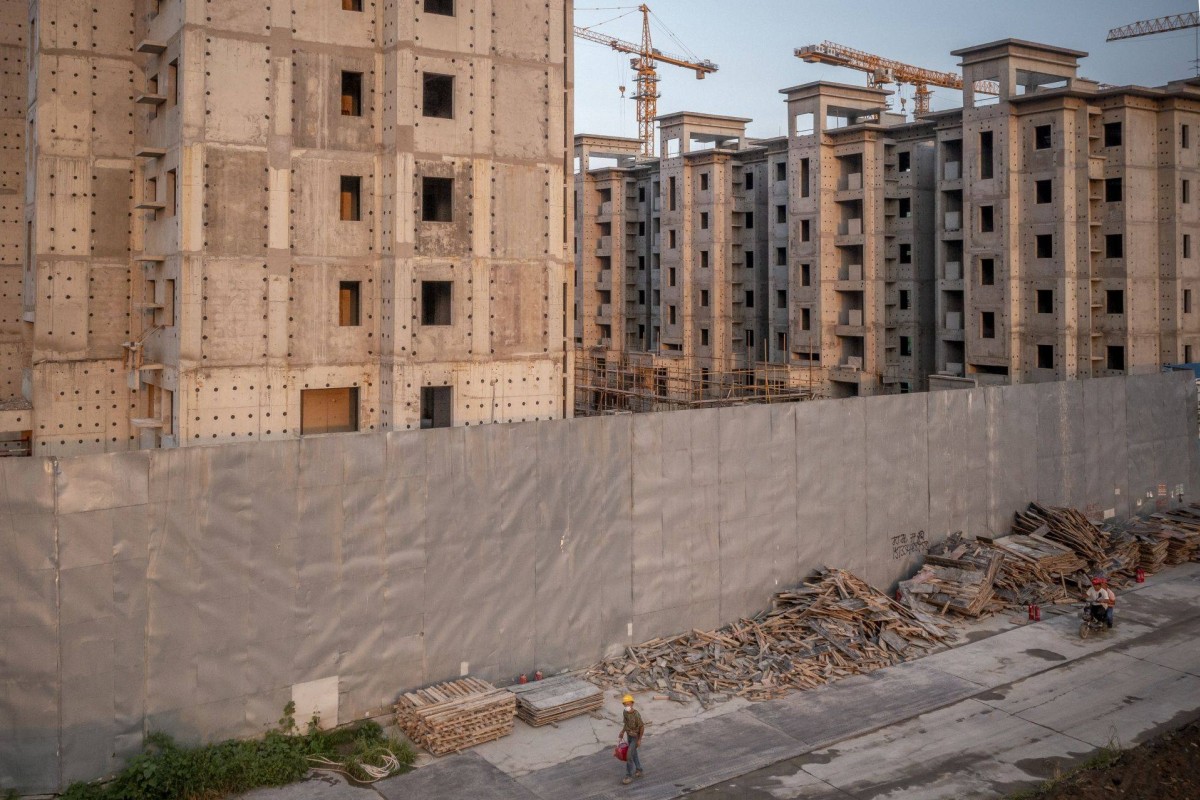 Workers leave a site in Beijing where residential buildings being developed by China Evergrande Group are still under construction, on July 29. Photo: Bloomberg