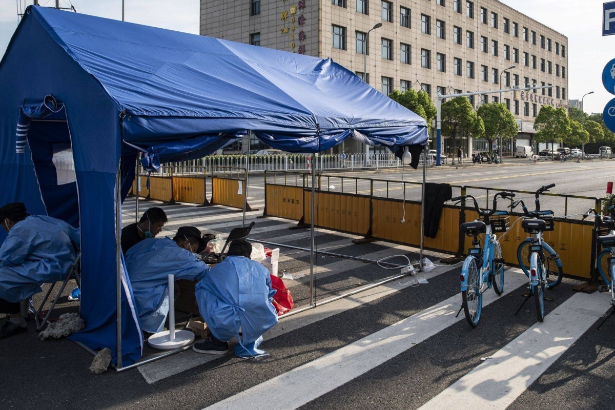 Security guards in protective gear staff a checkpoint as several city blocks are sealed off because of Covid-19 in the Meilong township of Shanghai on August 15. Photo: Bloomberg