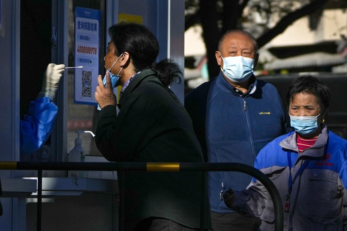 Residents wait in line to get their routine Covid-19 throat swab tests at a testing site in Beijing. Photo: AP