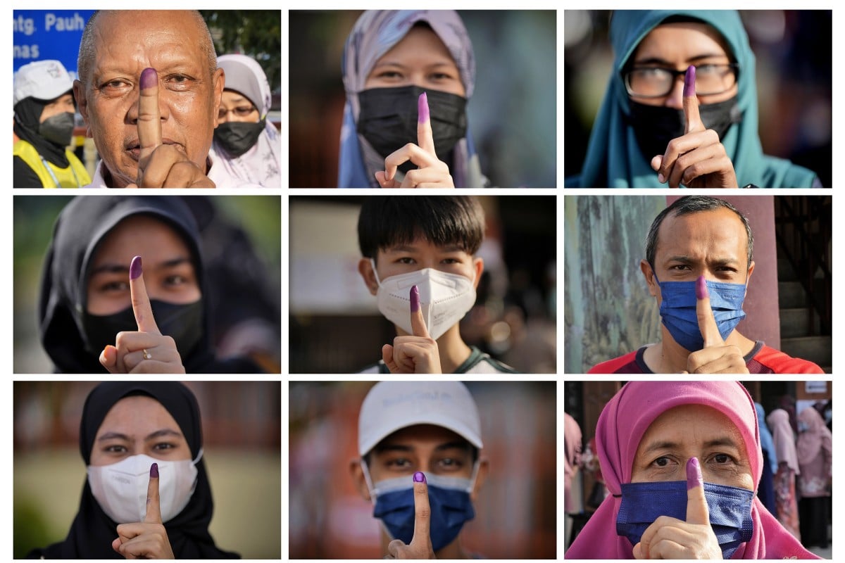 Malaysians pose with their inked fingers to mark that they have voted during the general election in Seberang Perai, Penang state. Photo: AP