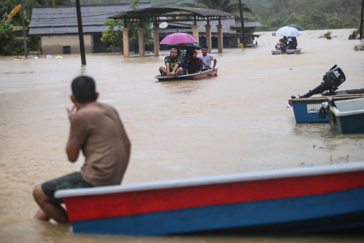 People use boats to travel through a flooded area in Kuala Terengganu, Malaysia, on Wednesday. Photo: EPA-EFE