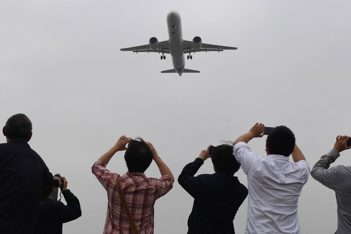 Spectators take photos of a Chinese passenger jet. Photo: AFP