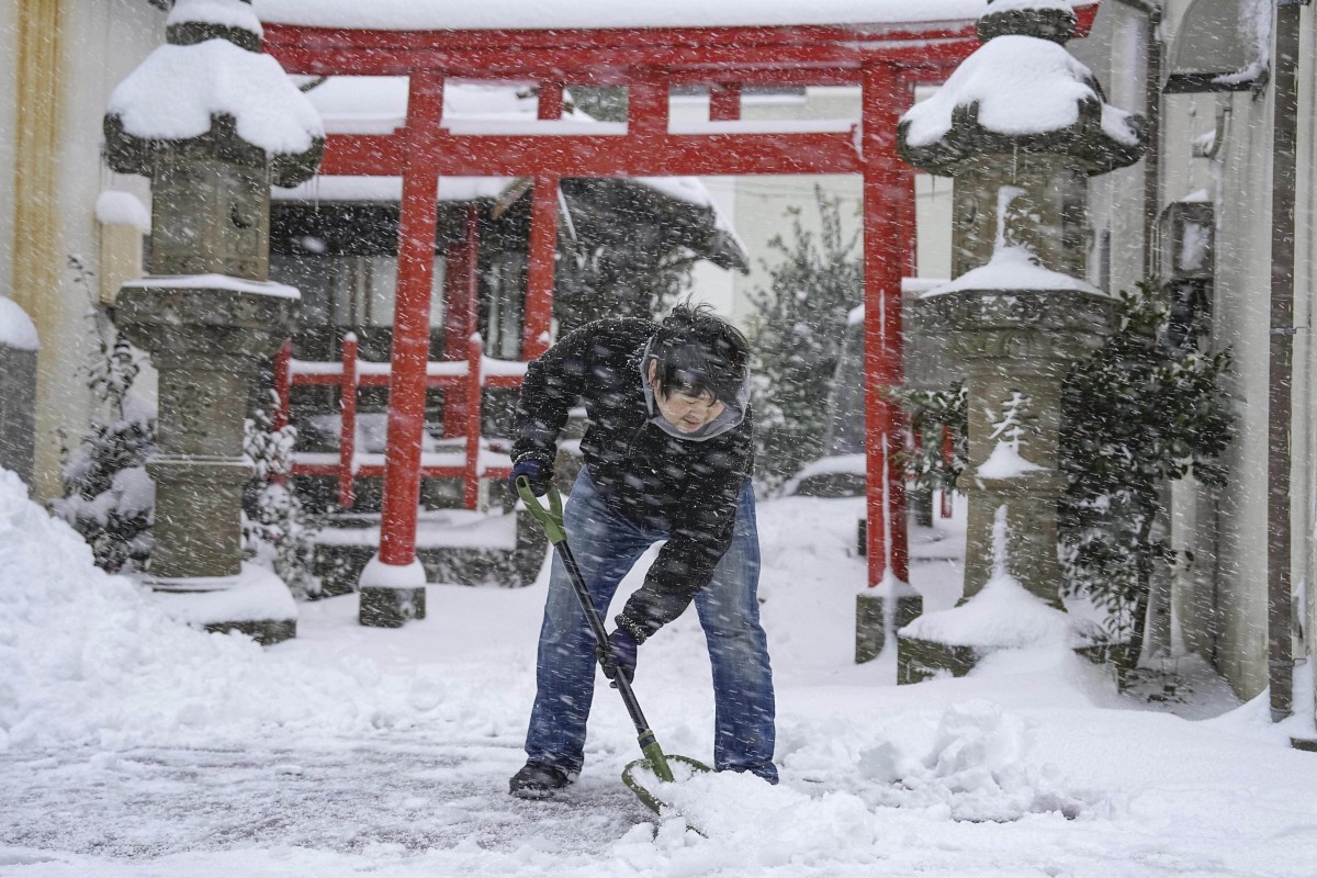 A person shovels snow in front of a shrine in Tottori, western Japan. Photo: Kyodo News via AP 