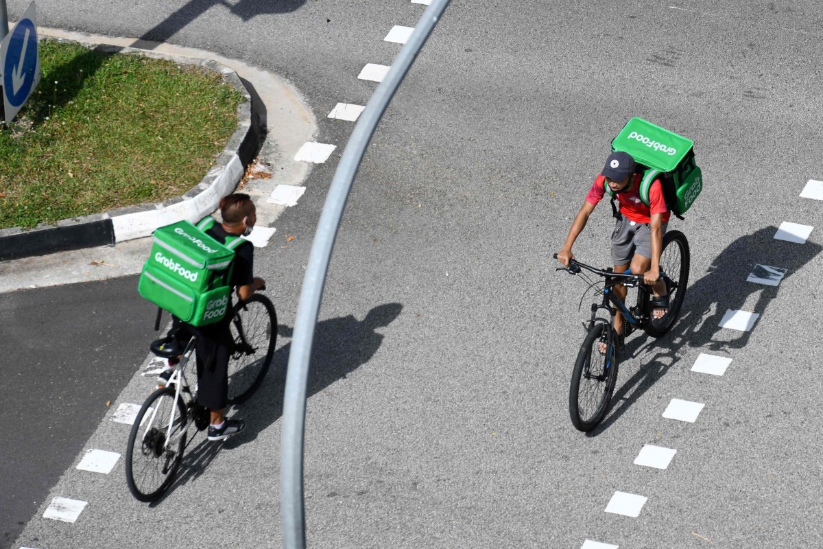Grab delivery cyclists in Singapore. The superapp has stirred controversy with its new Singapore director of public affairs and policy. Photo: AFP 