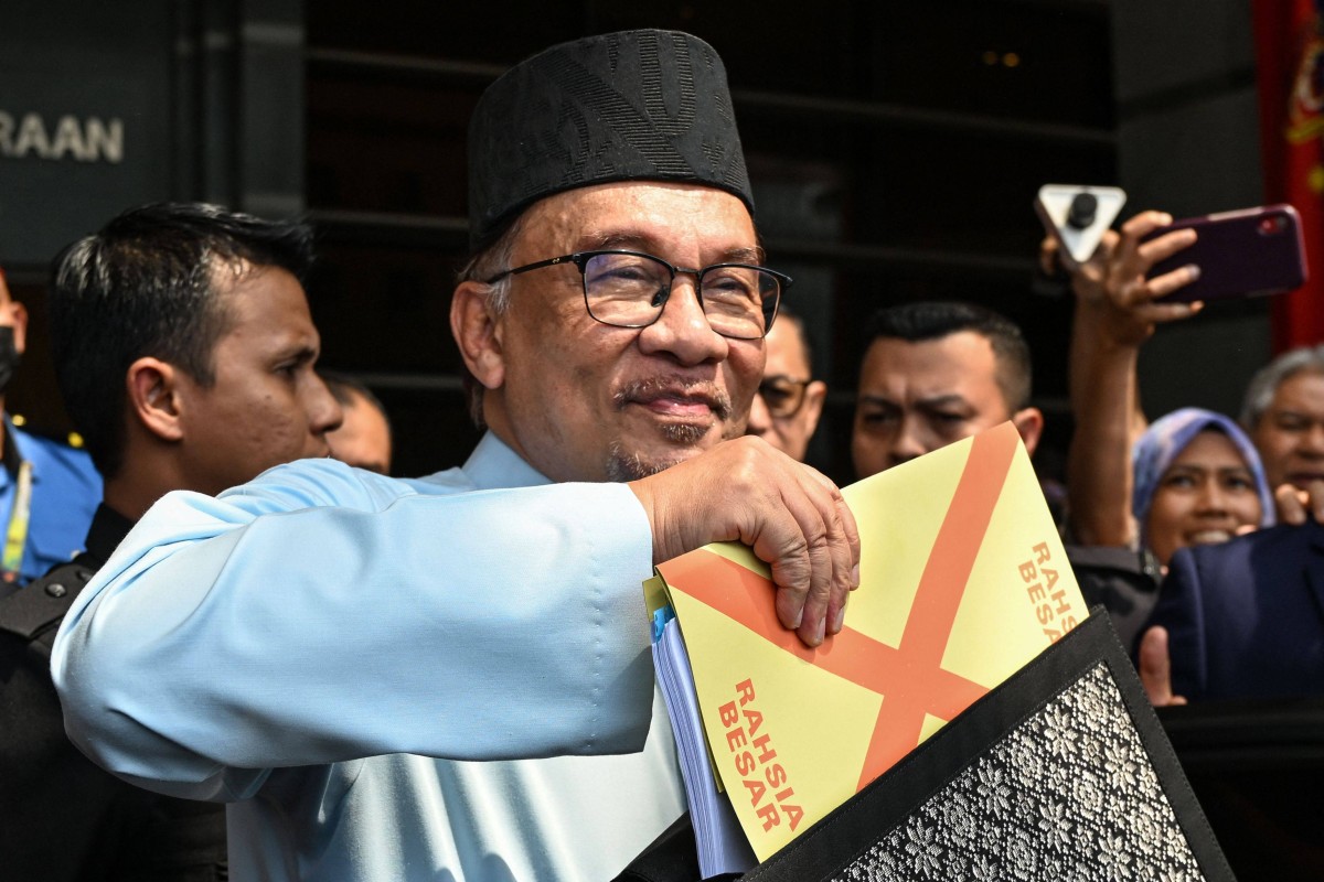 Malaysia’s Prime Minister and Finance Minister Anwar Ibrahim holds a briefcase containing his 2023 budget speech. Photo: AFP