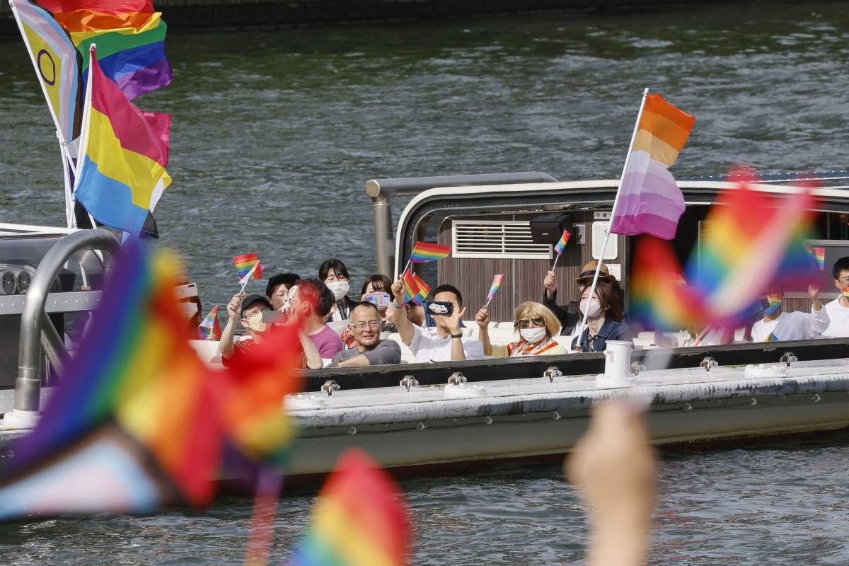 People wave rainbow flags aboard a boat during Pride Cruise Osaka on May 28. Photo: Kyodo