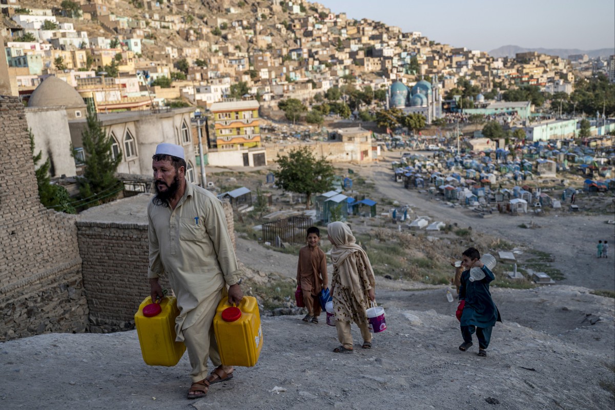 People carry drinking water in containers on a hillside in Kabul. Afghanistan risks starting a “water war” with Iran and other neighbouring nations. Photo: AFP