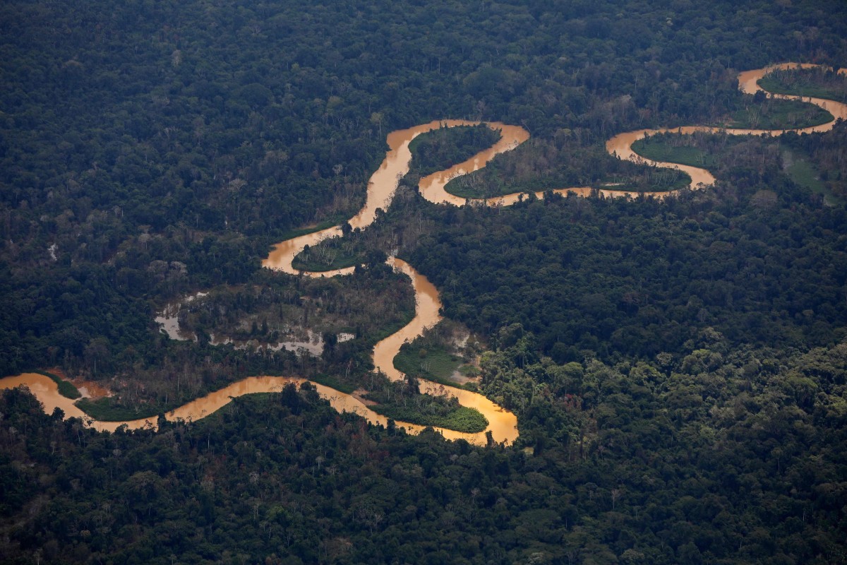(FILES) Aerial view of the Mucajai river at the Yanomami indigenous territory in the state of Roraima, Brazil on February 2, 2023. What’s the longest river in the world, the Nile or the Amazon? The question has fueled a heated debate for years. Now, an expedition into the South American jungle aims to settle it for good. Using boats powered by solar energy and pedal power, an international team of explorers plans to set off in April 2024 to definitively establish the source of the Amazon in the Peruvian Andes, then travel nearly 7,000 kilometers (4,350 miles) across Colombia and Brazil, to the massive river’s mouth on the Atlantic. (Photo by MICHAEL DANTAS / AFP)