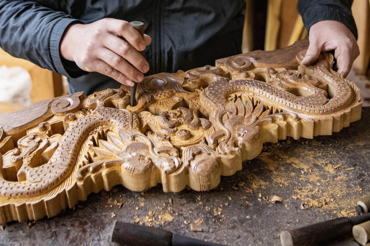 A worker making classical wood-carved furniture in a factory in Qionghai, Hainan, southern China. A revival in domestic demand for traditional carved furniture has helped revive old skill sets that disappeared when copies of foreign furniture styles became popular. Photo: AFP