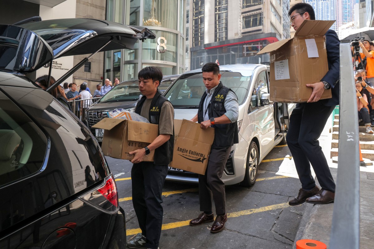 Police officers carry boxes out of a building in Central on September 18, in the wake of the JPEX scam. Photo: Jelly Tse Image Credit: South China Morning Post