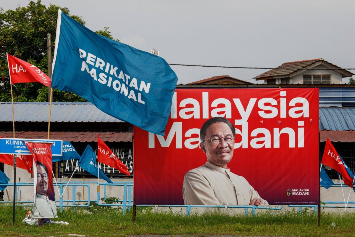 A poster featuring Malaysian Prime Minister Anwar Ibrahim is seeen next to Perikatan Nasional and Pakatan Harapan flags in Selangor ahead of last month’s state polls. Photo: Bloomberg