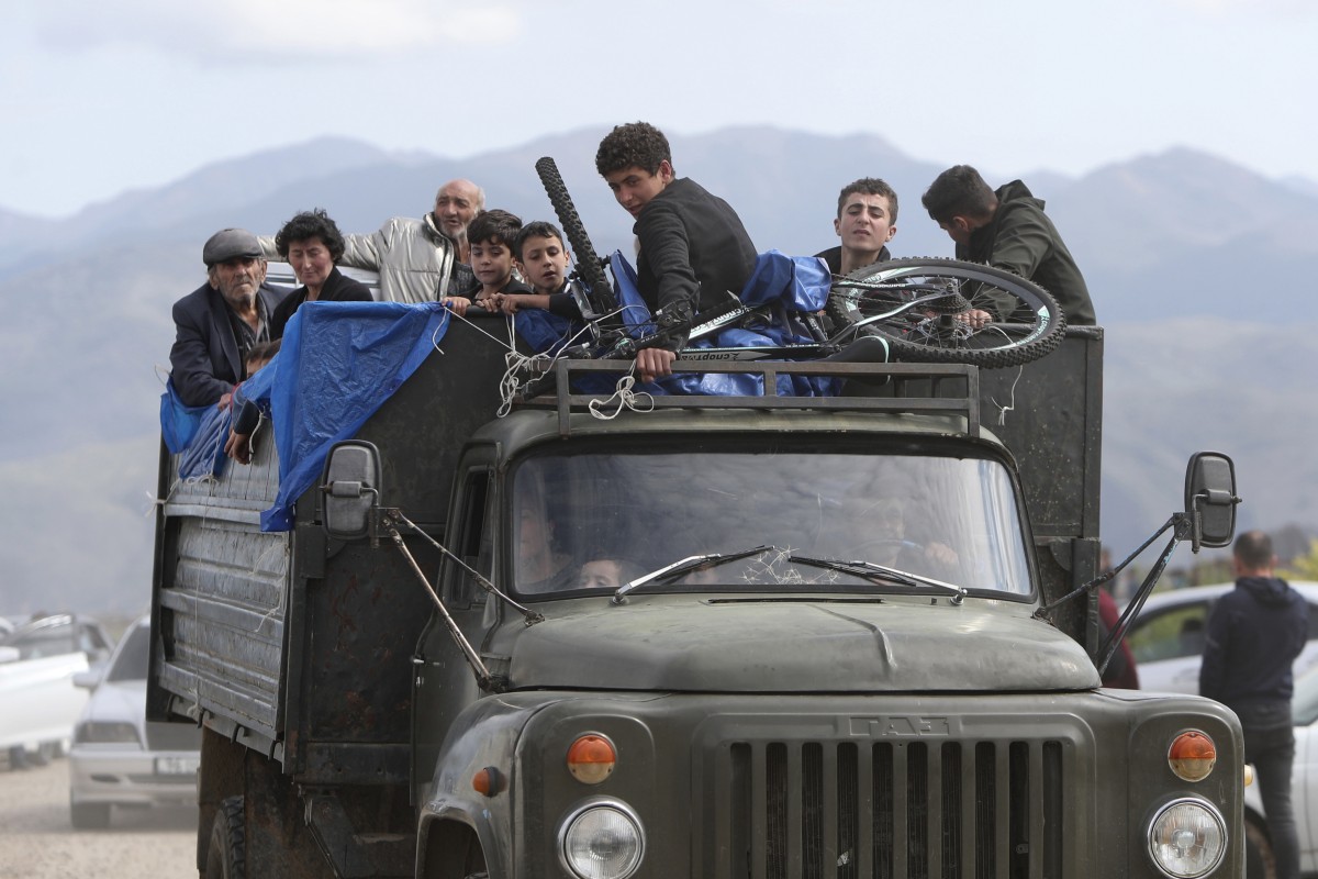 Ethnic Armenians from Nagorno-Karabakh ride a truck on their way Armenia. Photo: Photolure photo via AP)
