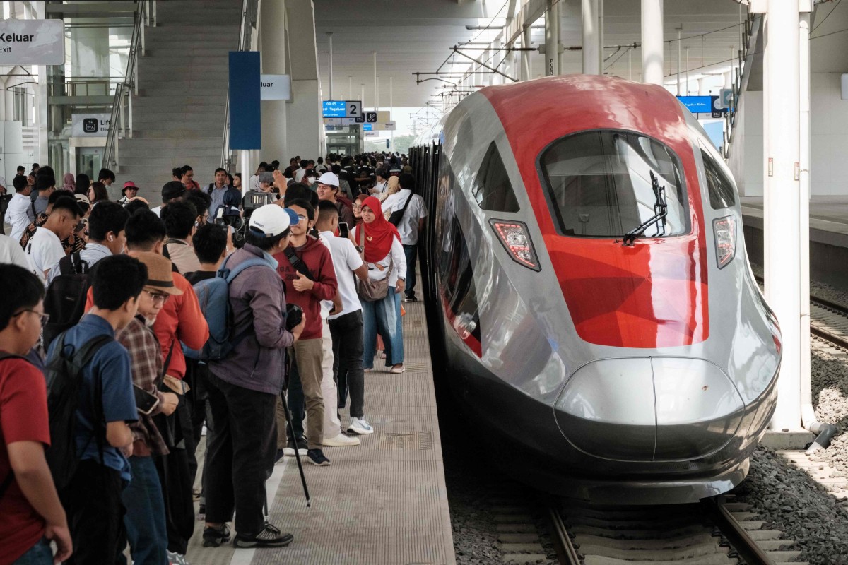 People take pictures with a train on the Jakarta-Bandung high-speed railway. After years of delays and budget blowouts, the US$7.2 billion project is set to open to the public on Sunday. Photo: AFP