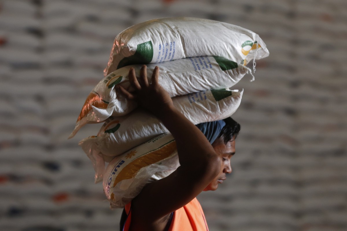 An Indonesian worker carries sacks of rice to be distributed to poor families in Banda Aceh. Photo: EPA-EFE