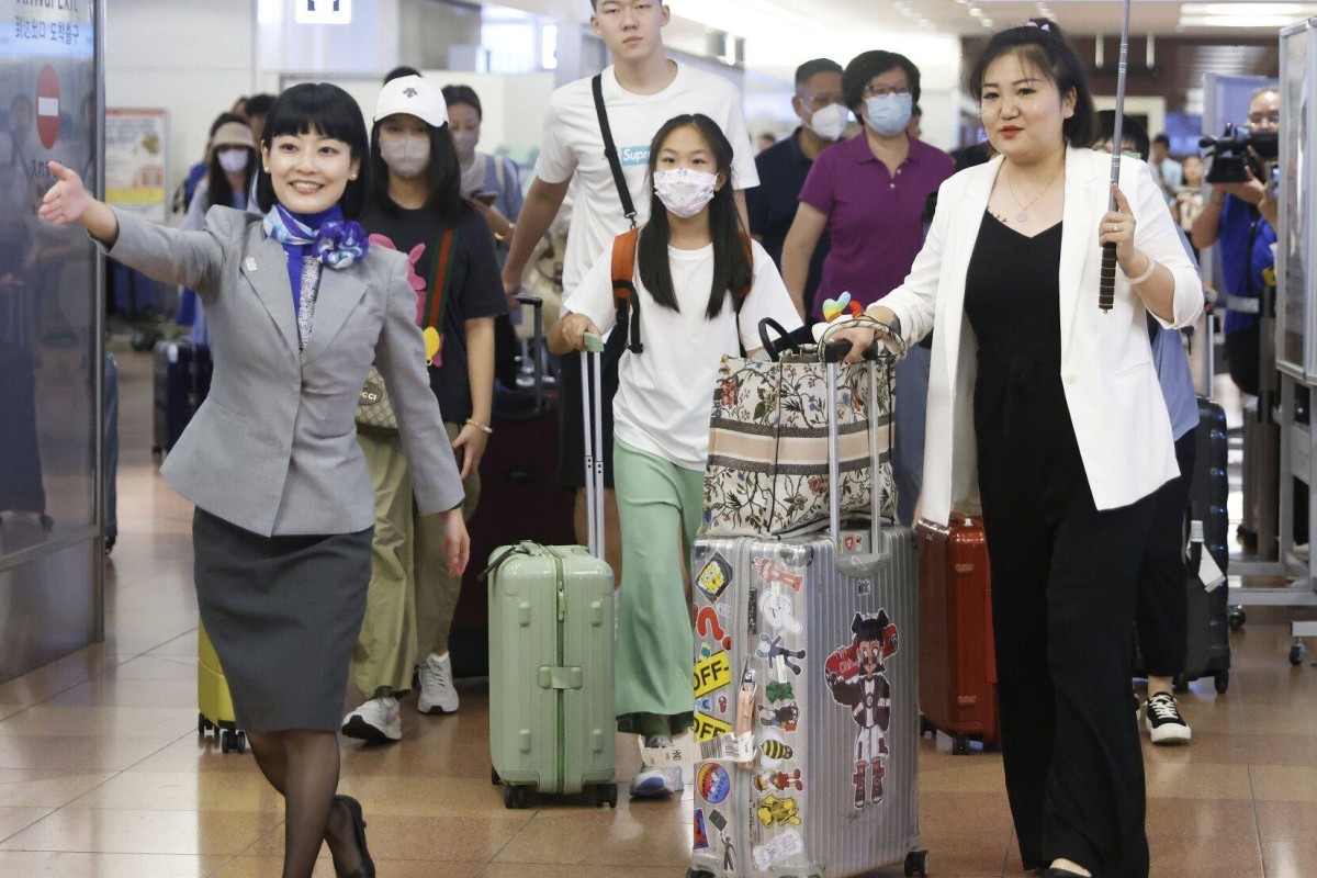 An All Nippon Airways employee escorts a Chinese tour group through Tokyo’s Haneda Airport in August. Tourist footfall that month was up 1,000 per cent year on year, according to the Japan Department Stores Association. Photo: Bloomberg