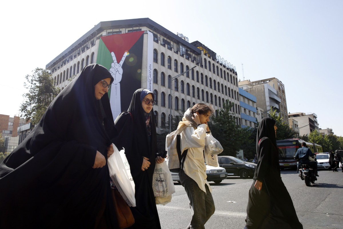 Iranian women walk next to a huge Palestinian flag hanging on a wall in Tehran. The Iranian government openly supported the Hamas attack on Israel and urged the Muslim community to stand by the Palestinians. Photo: EPA-EFE