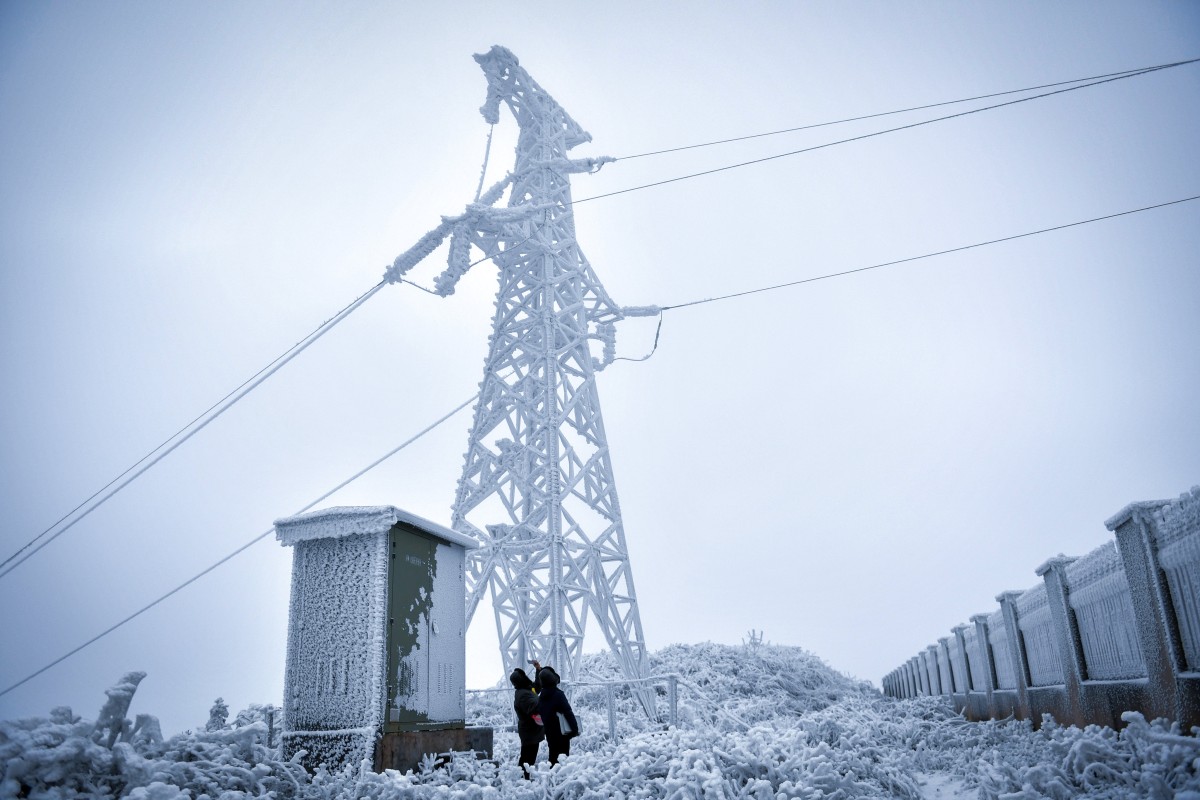 Power supply technicians check icing conditions at an observation station in central China’s Hunan province last December. Regular monitoring and new technology have helped reduce the impact of severe storms on power supplies. Photo: Xinhua