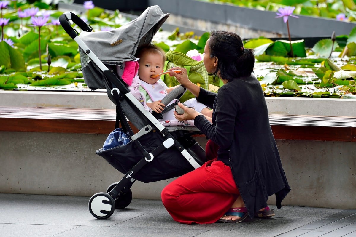 A woman feeds her baby at a Singapore park. Photo: Shutterstock