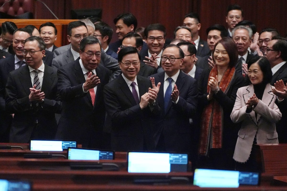 City leader John Lee (third left front, purple tie) and Legislative Council members  celebrate the passing of the Article 23 legislation. Photo: Eugene Lee