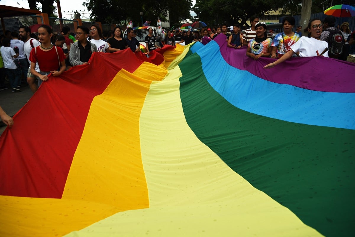 Members of the LGBTQ community carry a giant rainbow flag at a pride march at a sports complex in Marikina City, east of Manila on June 30, 2018. Photo: AFP