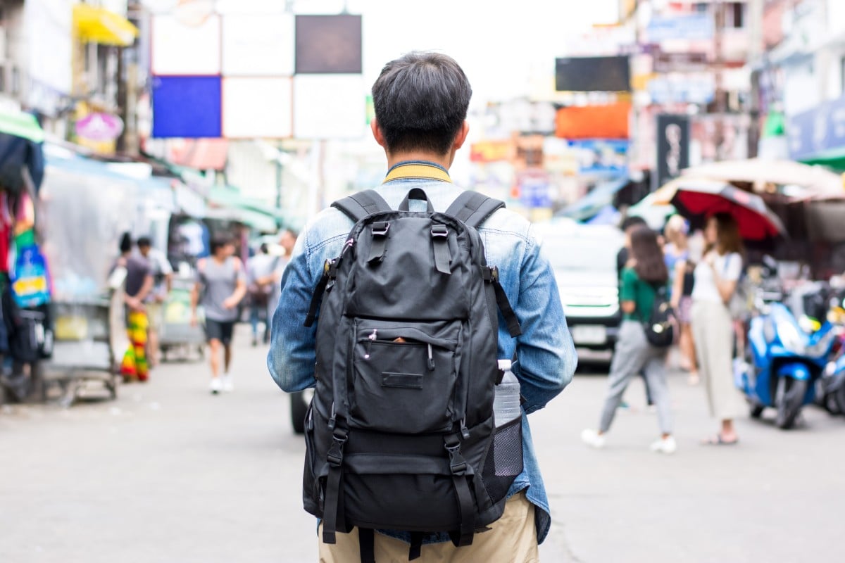 A backpacker walks through the Khao San Market in Bangkok, Thailand. Tile Pile passes on his beginner backpacking tips for Southeast Asia to his son as he starts his first solo trip. Photo: Shutterstock
