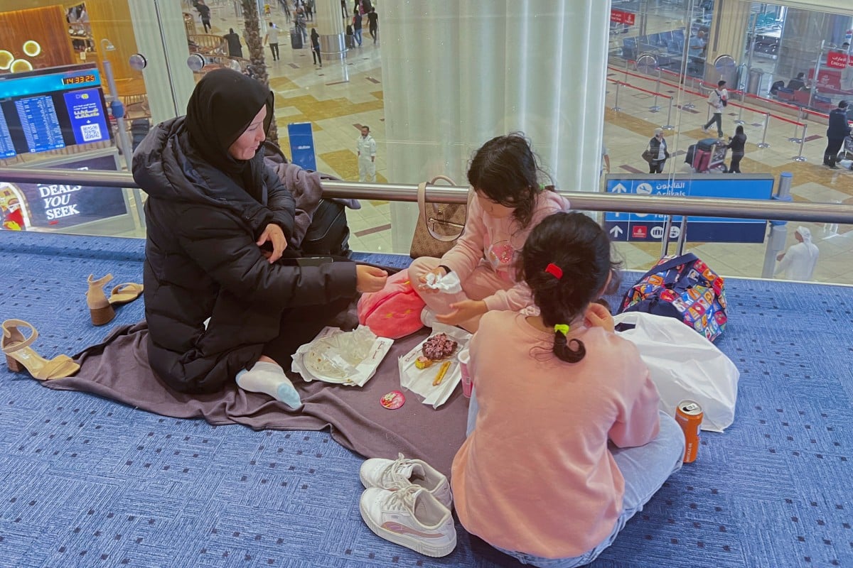 A woman and her daughters eat as they wait for their flight after a rainstorm hit Dubai, causing delays at Dubai International Airport, United Arab Emirates. Photo: Reuters