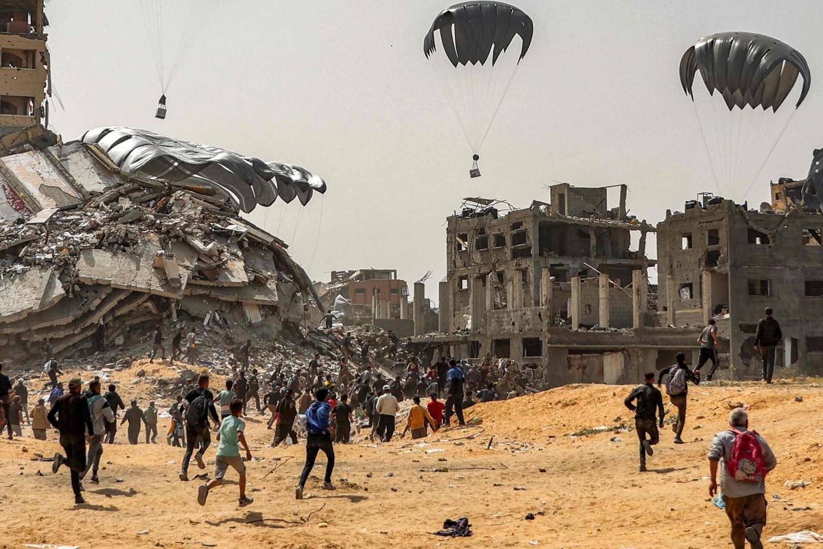 People rush to landing humanitarian aid packages dropped over the northern Gaza Strip on April 23, 2024 amid the ongoing conflict in the Palestinian territory between Israel and the militant group Hamas. Photo: AFP
