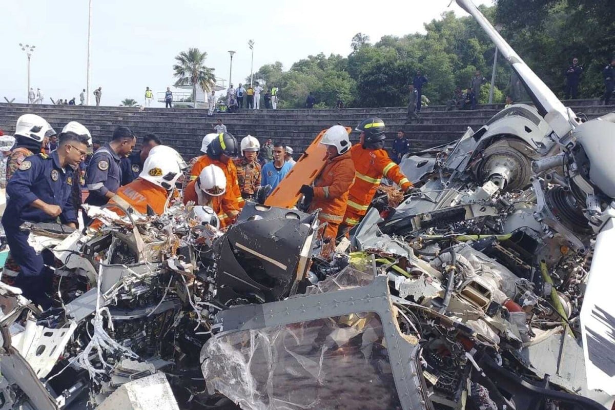 Rescue personnel inspect the crash site of two helicopters in Lumut, Perak, on April 23. Photo: Fire & Rescue Department of Malaysia via AP