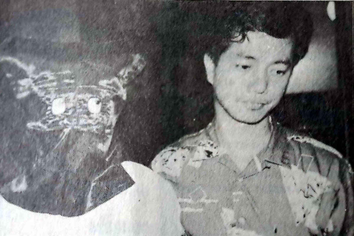 A suspect held in connection with what a judge called a “gruesome revenge attack” on a triad leader’s 14-year-old son is escorted to the scene of the crime in June 1988. Fung Kam-keung was convicted of murder for the killing, and in 1990 lost an appeal against his sentence. Photo: SCMP