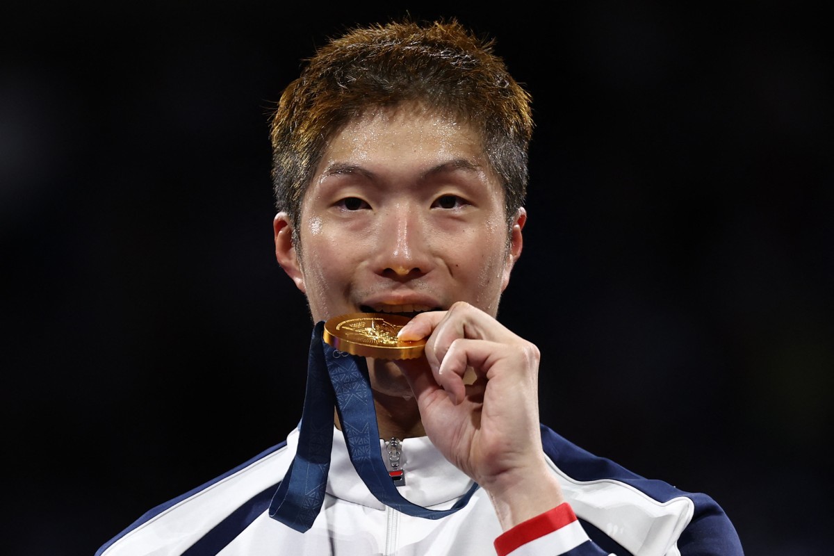 Hong Kong’s Cheung Ka-long takes a bite of his gold medal as he celebrates winning the individual men’s foil at the Grand Palais in Paris. Photo: AFP