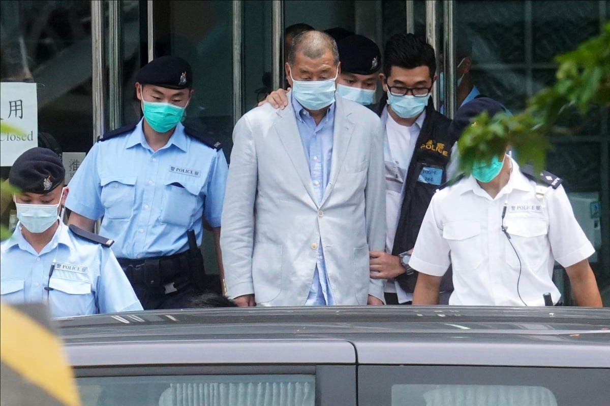 Officers escort Jimmy Lai during a police raid on Apple Daily’s office in August 2020. Photo: Winson Wong