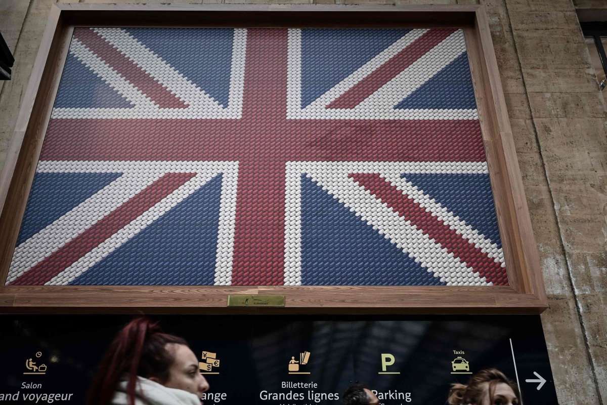 After Series Of Chaotic Votes Eu Leaders Urge Clarity From Britain People Walk Past A British Flag Depiction Near The Entrance Of Eurostar Terminal At