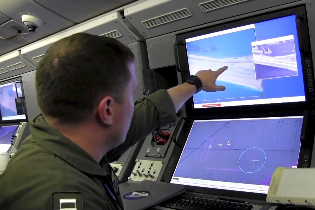 US Navy personnel point at a computer screen showing Chinese activity on the Fiery Cross Reef in the Spratly Islands in the South China Sea. An Australian scholar said Chinese ships pointed lasers at them during a flight over the disputed sea. Photo: Reuters