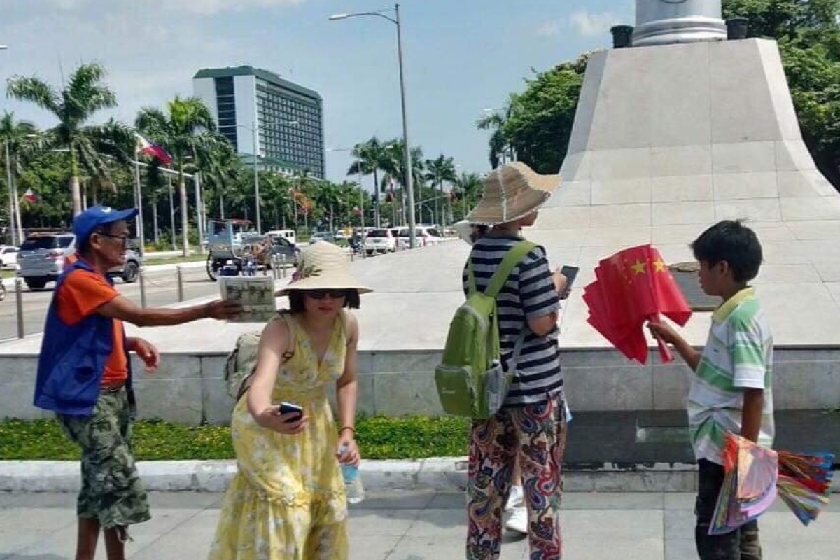 Four people seemingly selling Chinese flags at the Luneta Park in Manila. Photo: Facebook