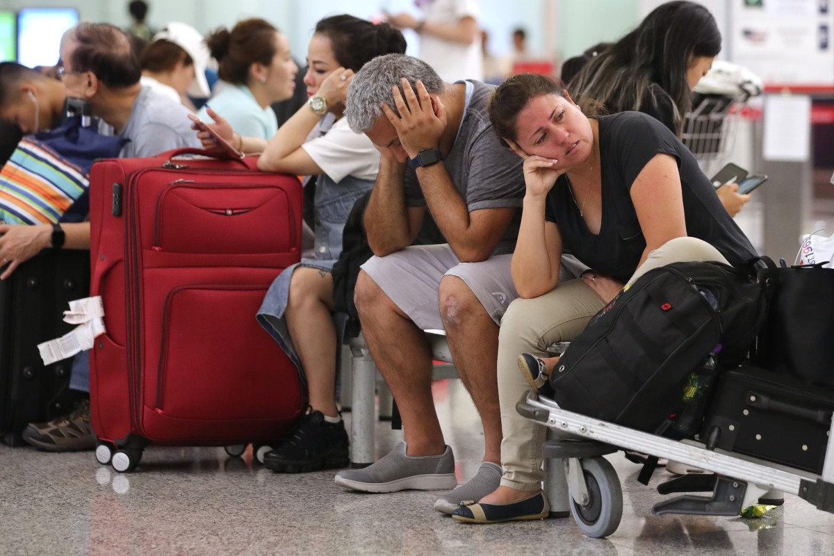 Tourists stranded at Hong Kong International Airport sit and wait for information after 180 departures were cancelled on Monday because of protests. Photo: Sam Tsang