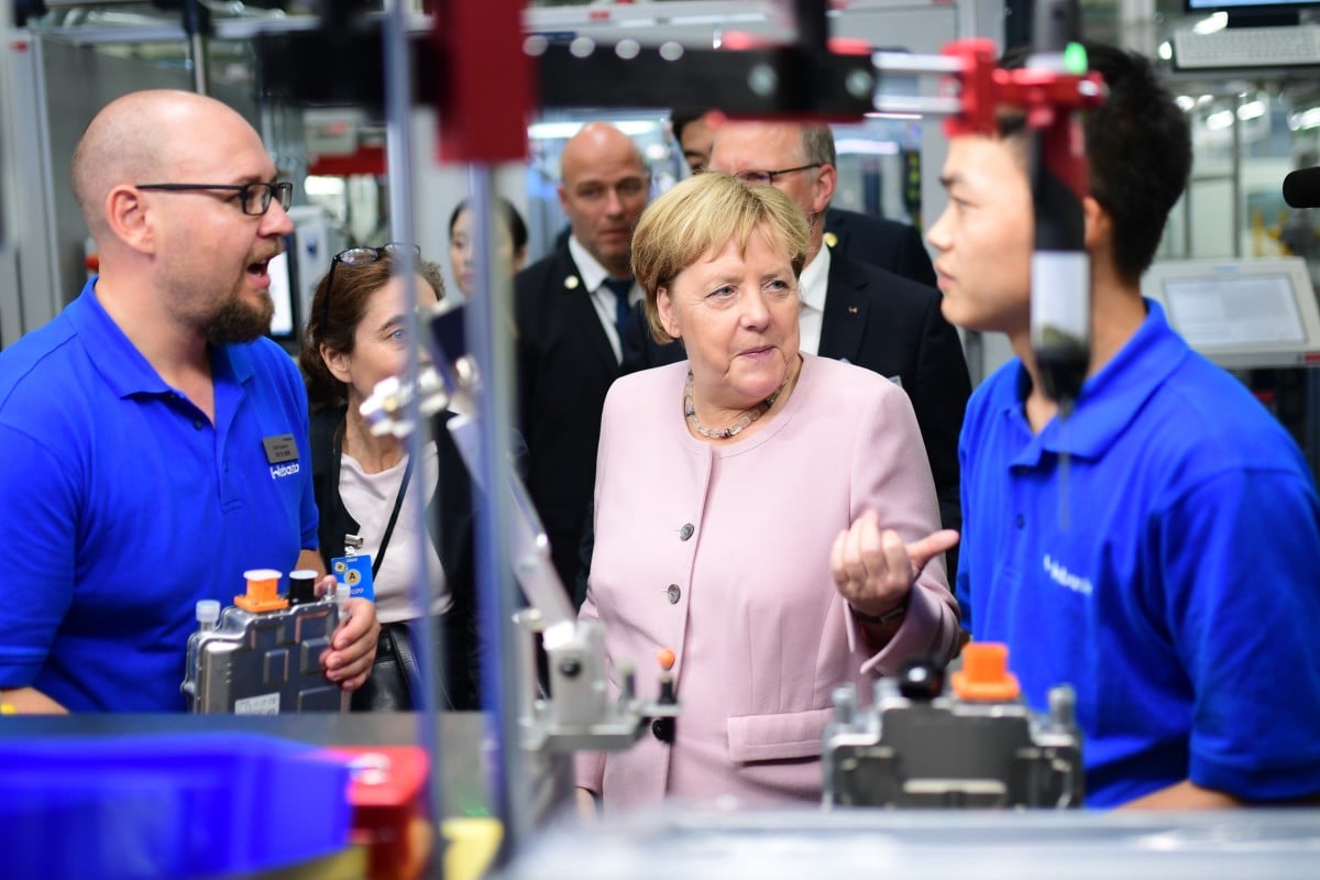 German Chancellor Angela Merkel (centre) talks to staff at manufacturer Webasto during a visit in Wuhan on Saturday. Photo: EPA-EFE