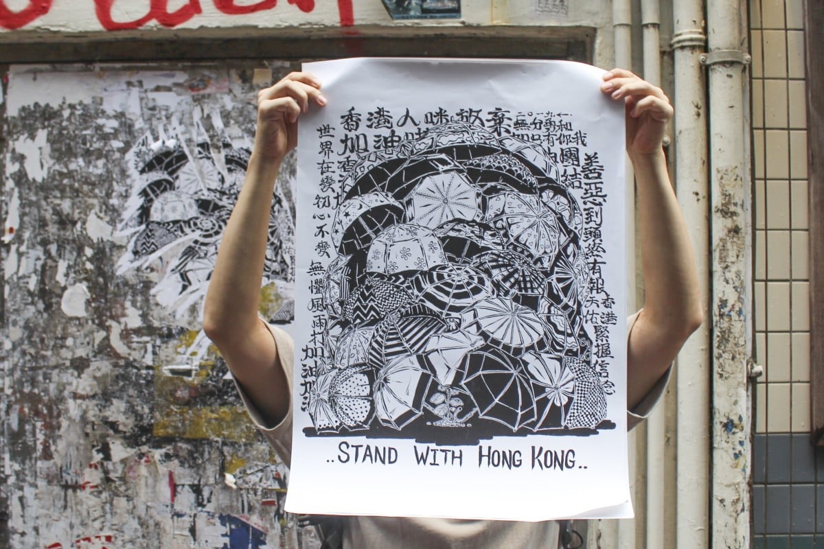 Graffiti artist Boms with his protest poster in a street in Mong Kok. Photo: Snow Xia