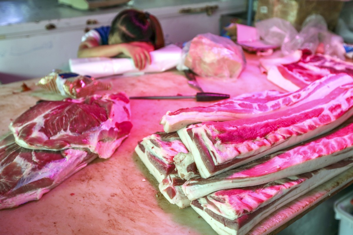 A pork vendor sleeps at a stall at a Beijing wholesale market. Photo: Simon Song